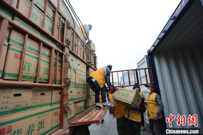 圖為鐵路裝卸作業(yè)人員正在將云南特色農產品裝入集裝箱?！詈?攝