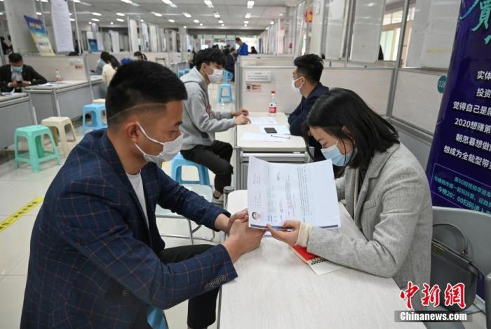 4月14日，招聘者在查看求職者簡歷。<a target='_blank'  data-cke-saved- >中新社</a>記者 王剛 攝