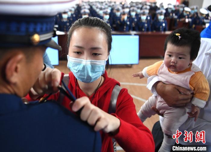 新消防員楊振的妻子彭莉與女兒現(xiàn)場見證丈夫加入“火焰藍(lán)”的神圣時(shí)刻?！⒅铱?攝