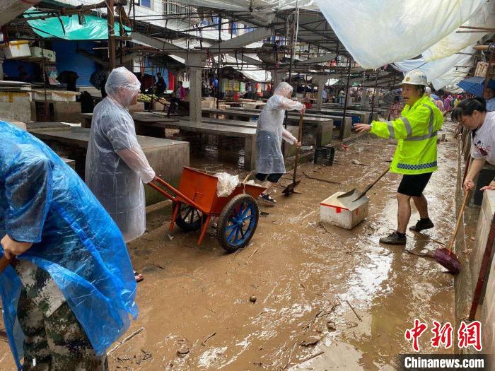 圖為7月26日，暴雨引發(fā)的洪水過境后，重慶萬州區(qū)分水鎮(zhèn)政府干部職工及志愿者清掃淤泥和垃圾。　　重慶萬州區(qū)委宣傳部供圖 攝
