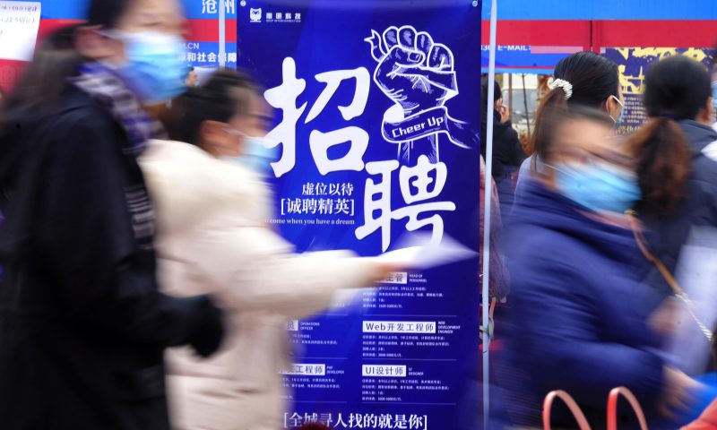 求職者從一家招聘企業(yè)的廣告牌前走過。新華社發(fā)（苑立偉 攝）