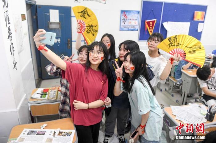 資料圖：6月6日，2021年高考前夕，湖南長沙同升湖實(shí)驗(yàn)學(xué)校高三年級，考生們在教室內(nèi)合影。 楊華峰 攝
