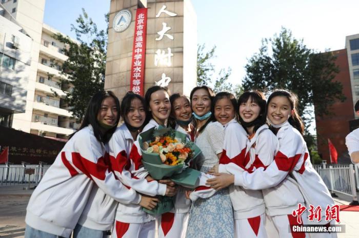 資料圖：6月10日，在北京人大附中高考考點(diǎn)外，考生們相擁拍照留念。當(dāng)日，北京市2021年高考結(jié)束?！?<a target='_blank'  data-cke-saved- ><p  align=